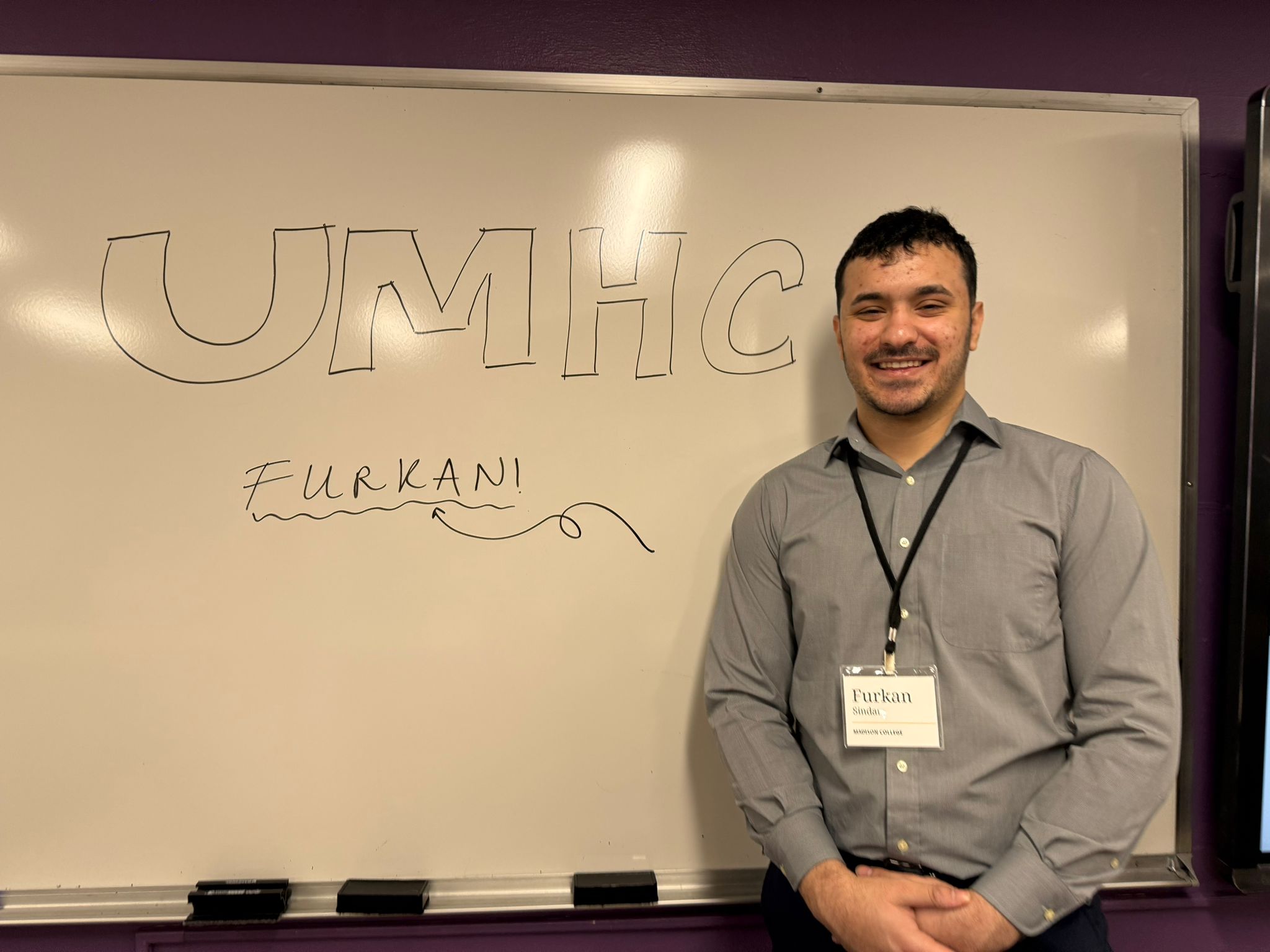 At UMHC whiteboard with conference badge