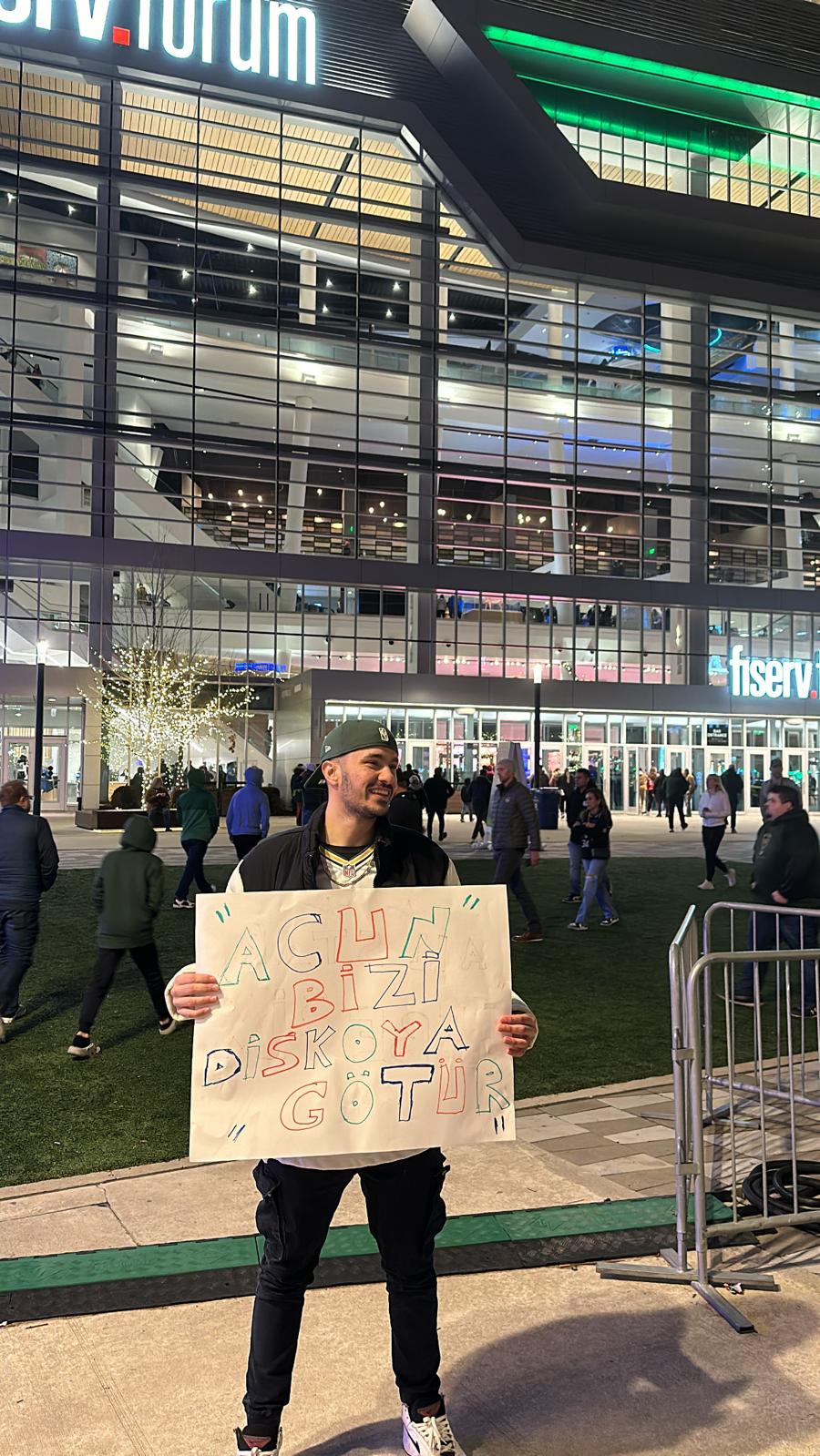 At the stadium holding sign and flag