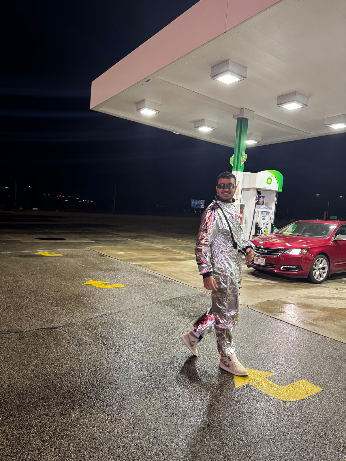 Walking in astronaut costume at a gas station at night